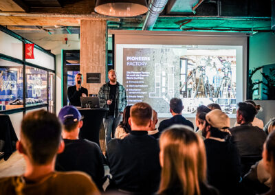 Bestuhlter Vortrag in der Pioneers Factory im Pioneers Club mit Leinwand und mehreren Teilnehmenden